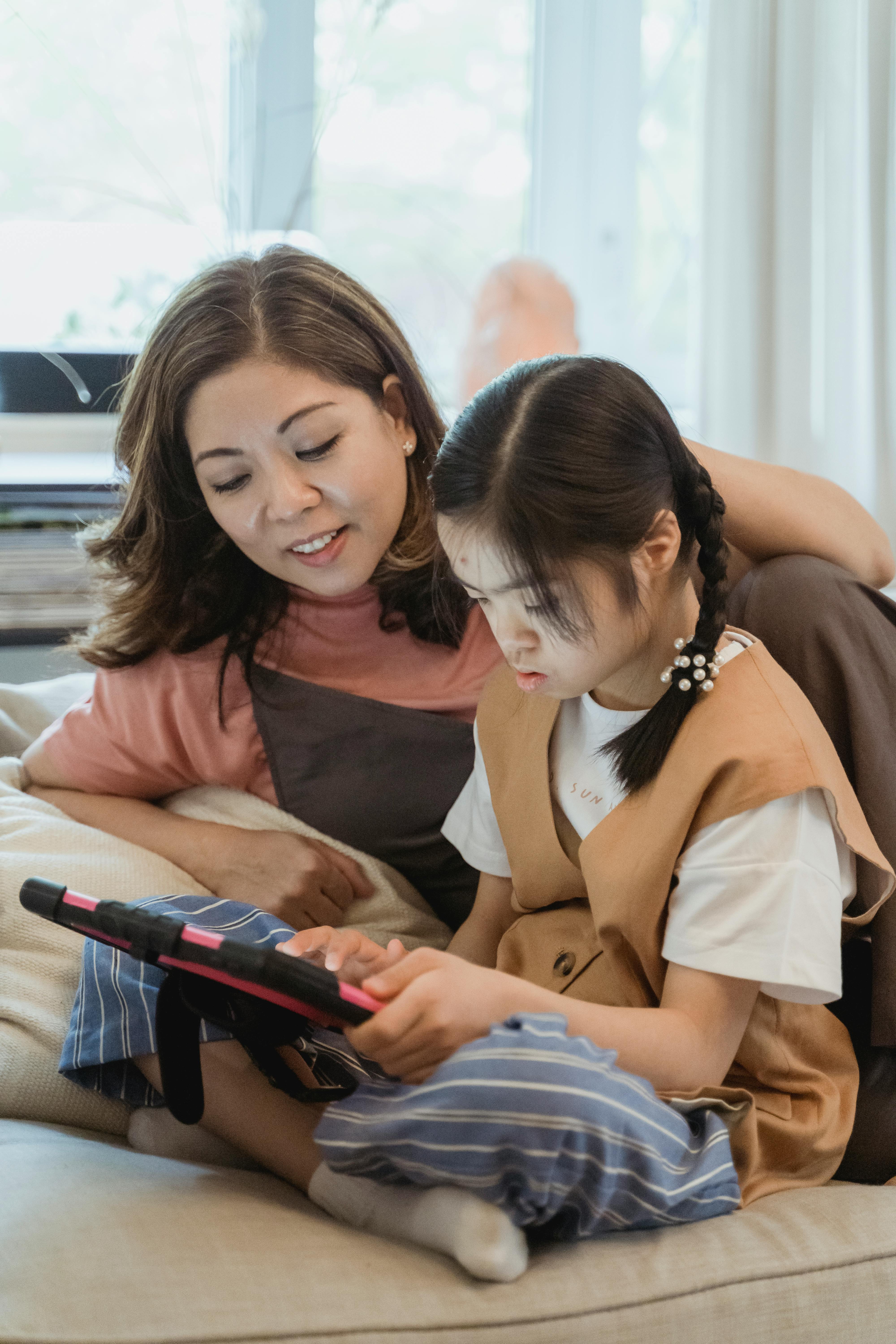 A mother and daughter using Sunspeak together on a couch